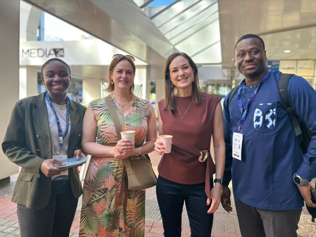 Four people standing together for a group photo at the Coffee Connect.